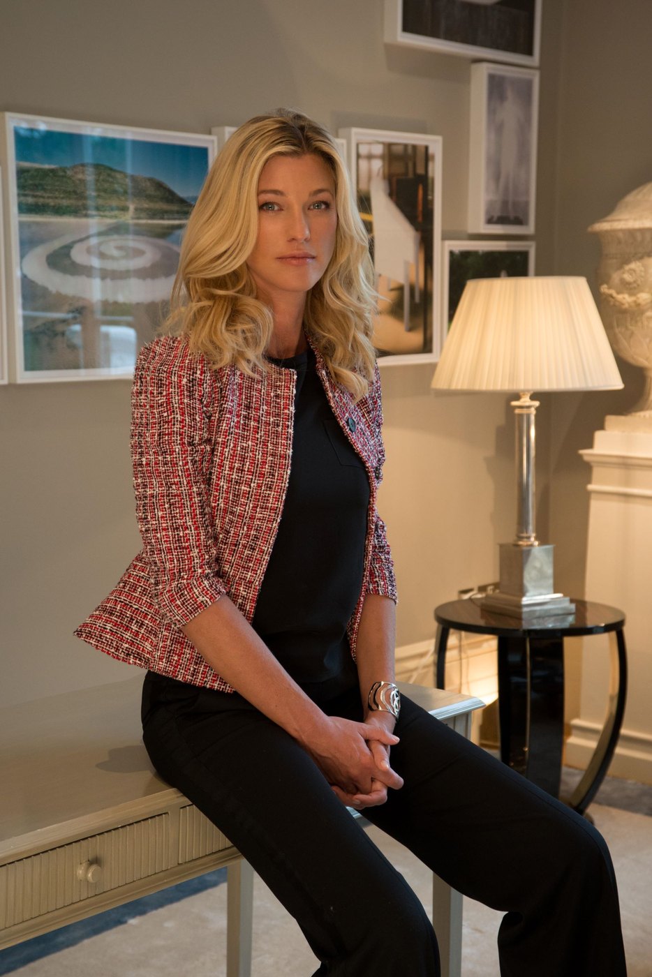 Nicole Junkermann sentada con una chaqueta de tweed en una sala tranquila, mirando a la cámara