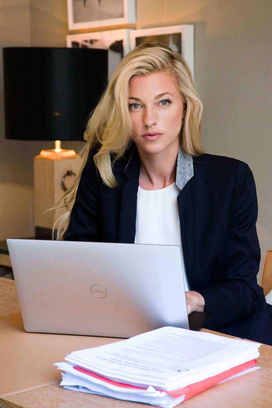 Nicole Junkermann en su escritorio, trabajando con un ordenador portátil junto a una lámpara de mesa