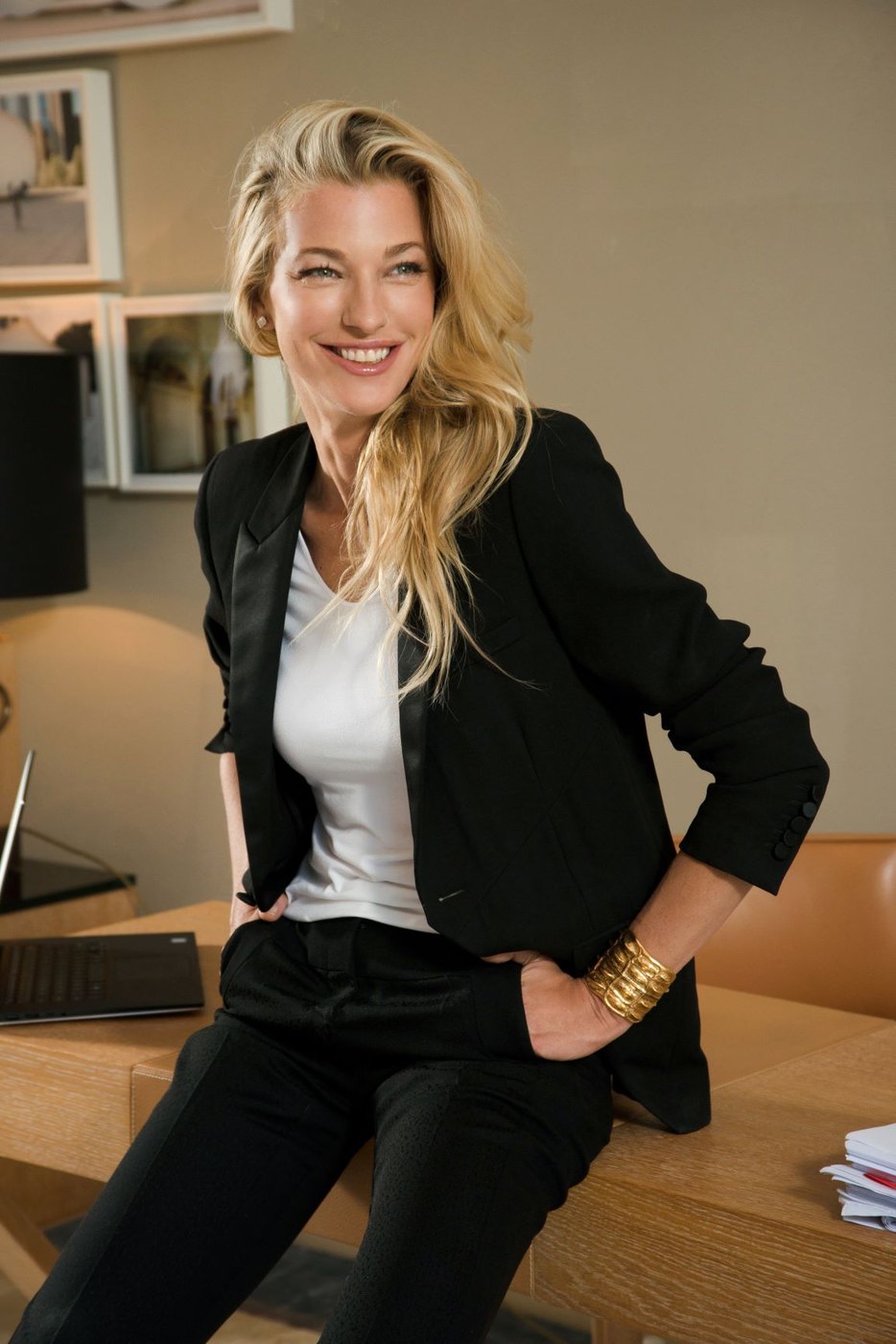 Nicole Junkermann sonríe apoyada en una mesa de trabajo en una oficina luminosa